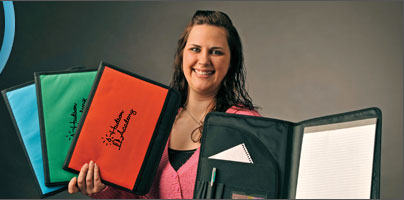Amsterdam Printing employee holding promotional calendars and padfolios