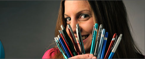 Jessica, Amsterdam Printing employee, is holding personalized pens in various colors